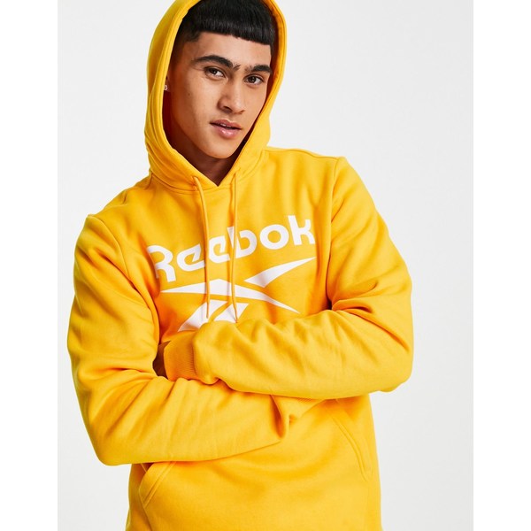 リーボック メンズ パーカー・スウェットシャツ アウター Reebok over the head hoodie with large logo in  orange Gold | asty