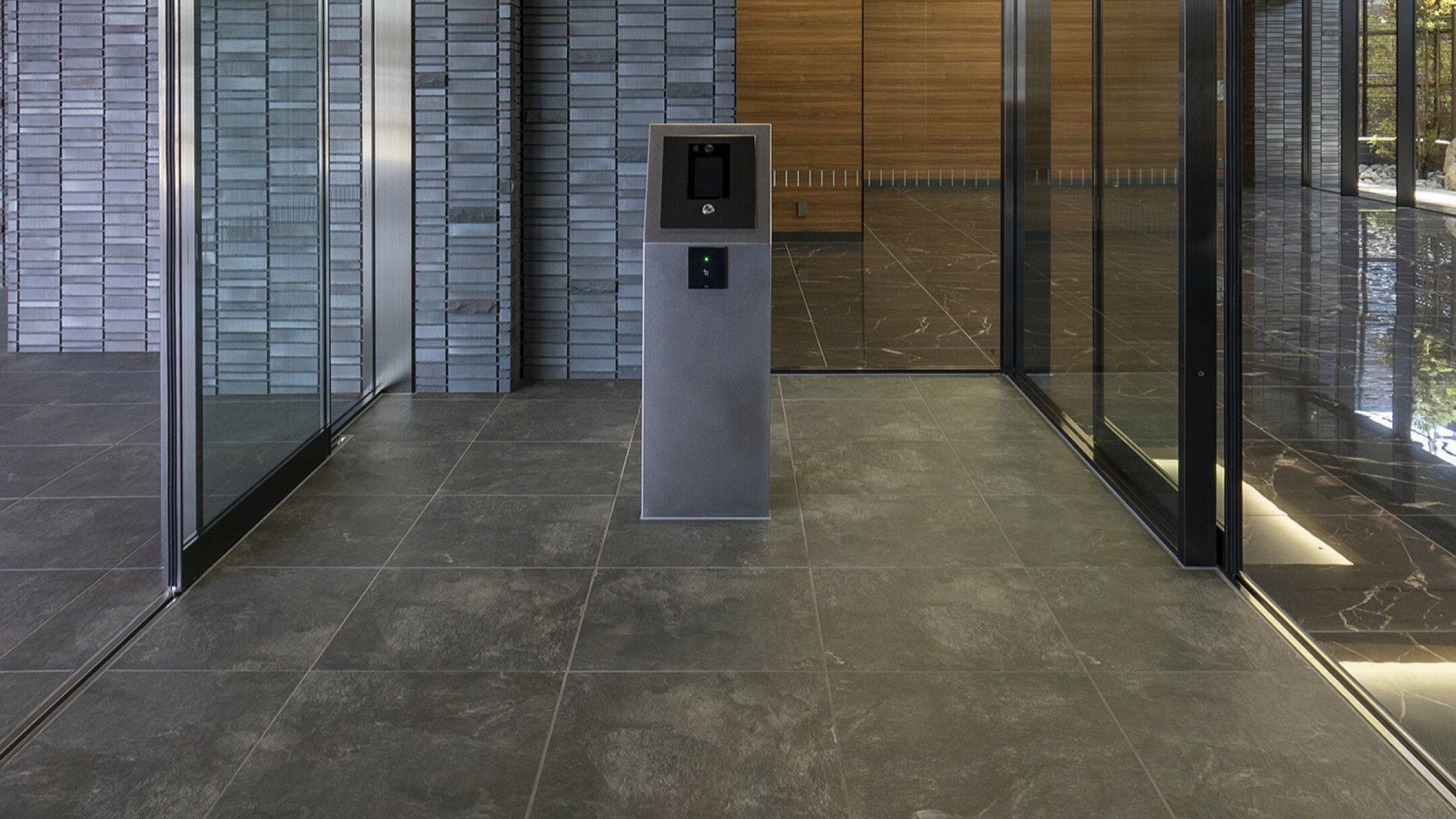 施工例：天然石風のブラックの600角タイルのメンションエントランスの床の施工例