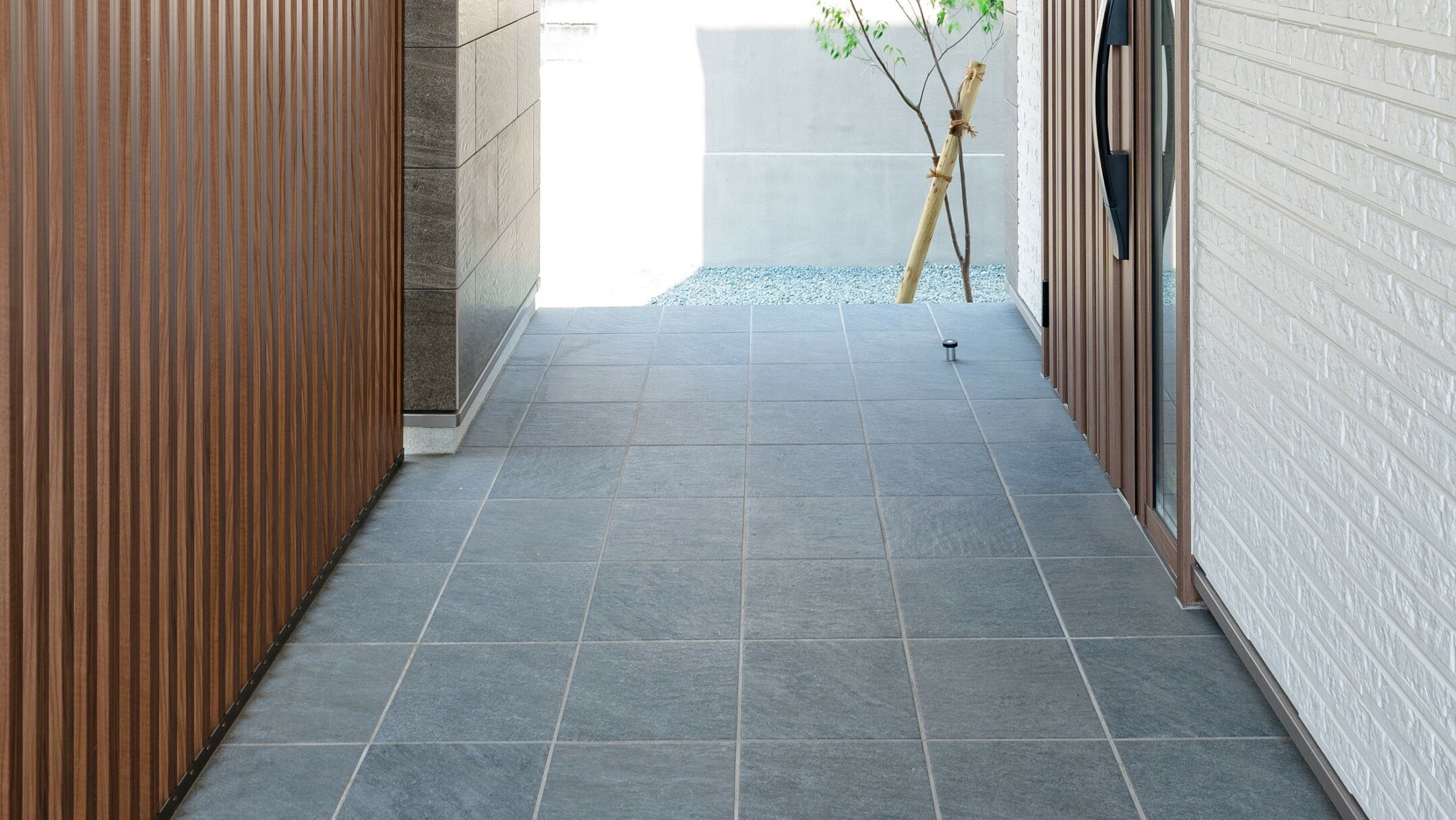 施工例：天然石風のグレーの300角タイルの玄関床の使用例写真