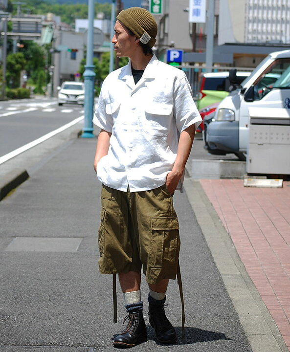 Workwear outfit with olive army cargo shorts, short-sleeve shirt, boots and knit cap