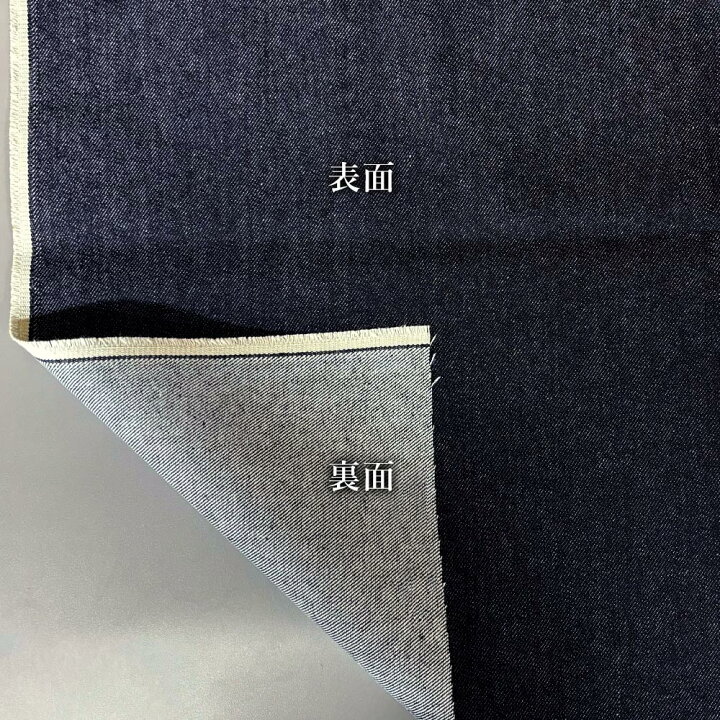 Dark indigo denim fabric folded back to show its much lighter reverse side