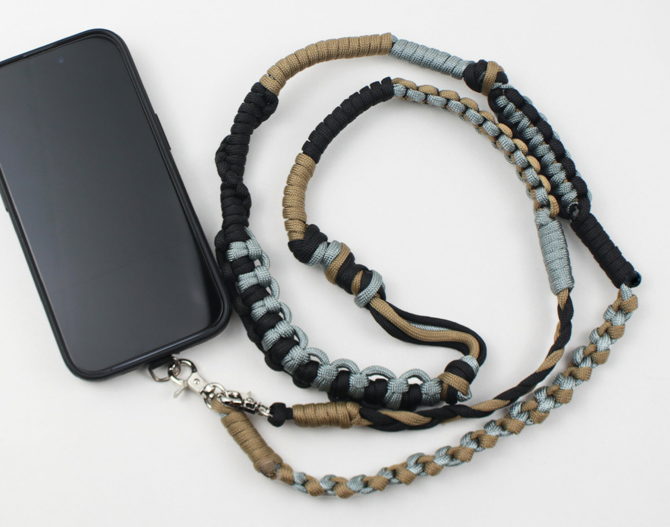 パラコードを使用したハンドメイドスマホショルダーです。編み方をこれでもかってくらい組み合わせて、カラー自体はシンプルですが個性的な作品に仕上がりました。編み方次第で見え方が変わるのもパラコードクラフトの魅力の一つです。