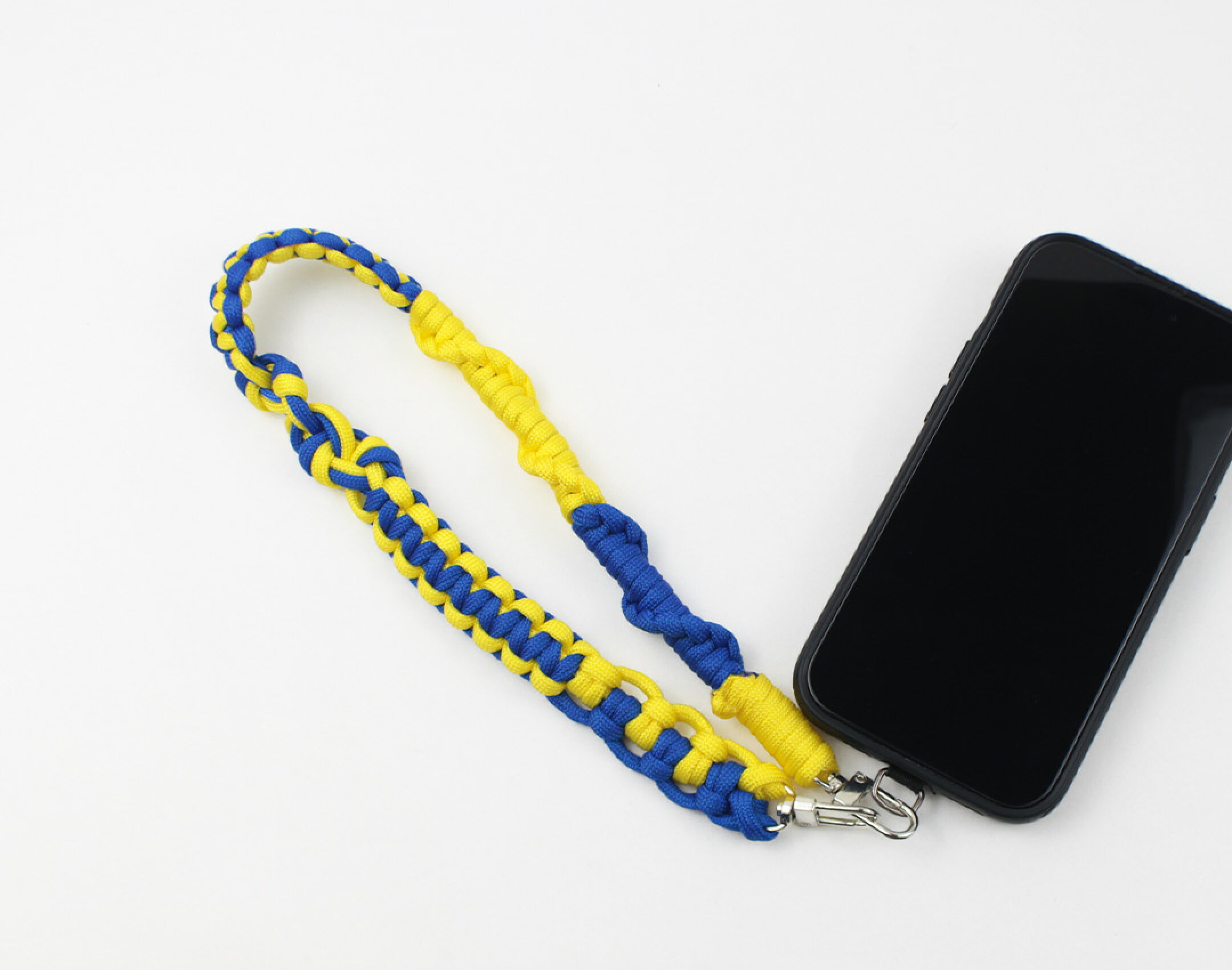 パラコードを使用したハンドメイドスマホストラップです。黄色と青を組み合わせてあの大型家具店をイメージするようなデザインに。とてもきれいな発色なので目立つこと間違いなし。途中編み方を変えて各色が交わるようにしました。