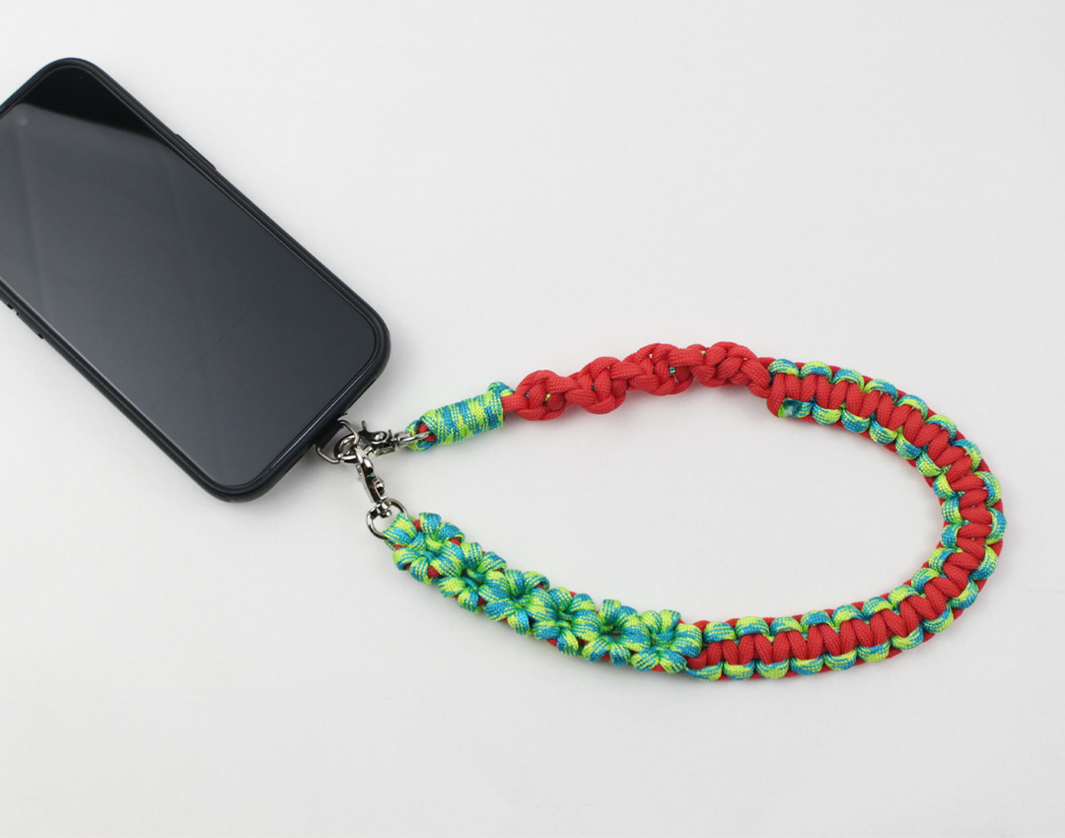 パラコードを使用したハンドメイドスマホストラップです。赤と柄物を組み合わせた作品です。カモフラ系のカラーは組み合わせが難しいですが、単色と組み合わせることで調和がとれて美しく仕上がります。男性にもおすすめの作品です。