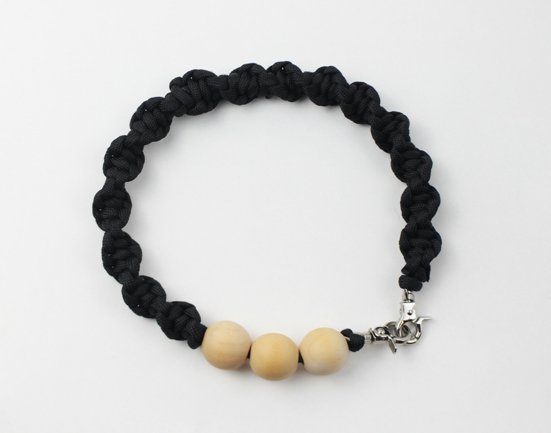 パラコードを使用したハンドメイドスマホストラップです。ウッドビーズを使用したシンプルな作品です。編み方も同じにして強弱の出ないデザインに。３連木製ビーズが可愛い。バッグやポケットからチラッと見せるのもいいですね。