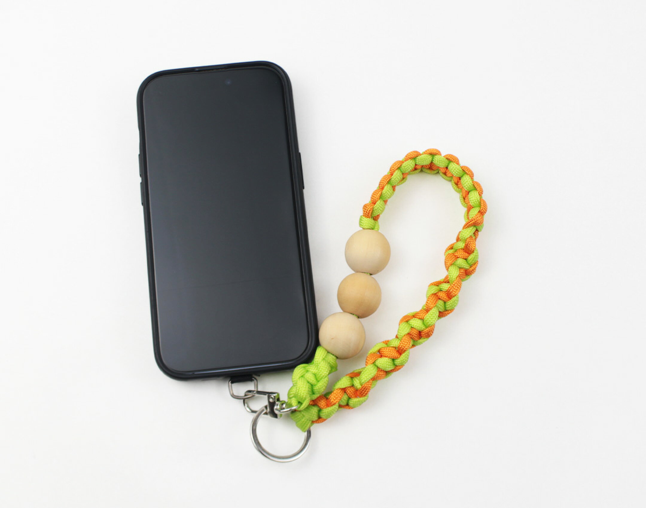 パラコードを使用したハンドメイドスマホストラップです。明るいカラーのパラコードにウッドビーズを組み合わせました。グリーンとオレンジが木目とマッチしてとても可愛いです。スマホの落下防止にも便利で実用的な作品です。