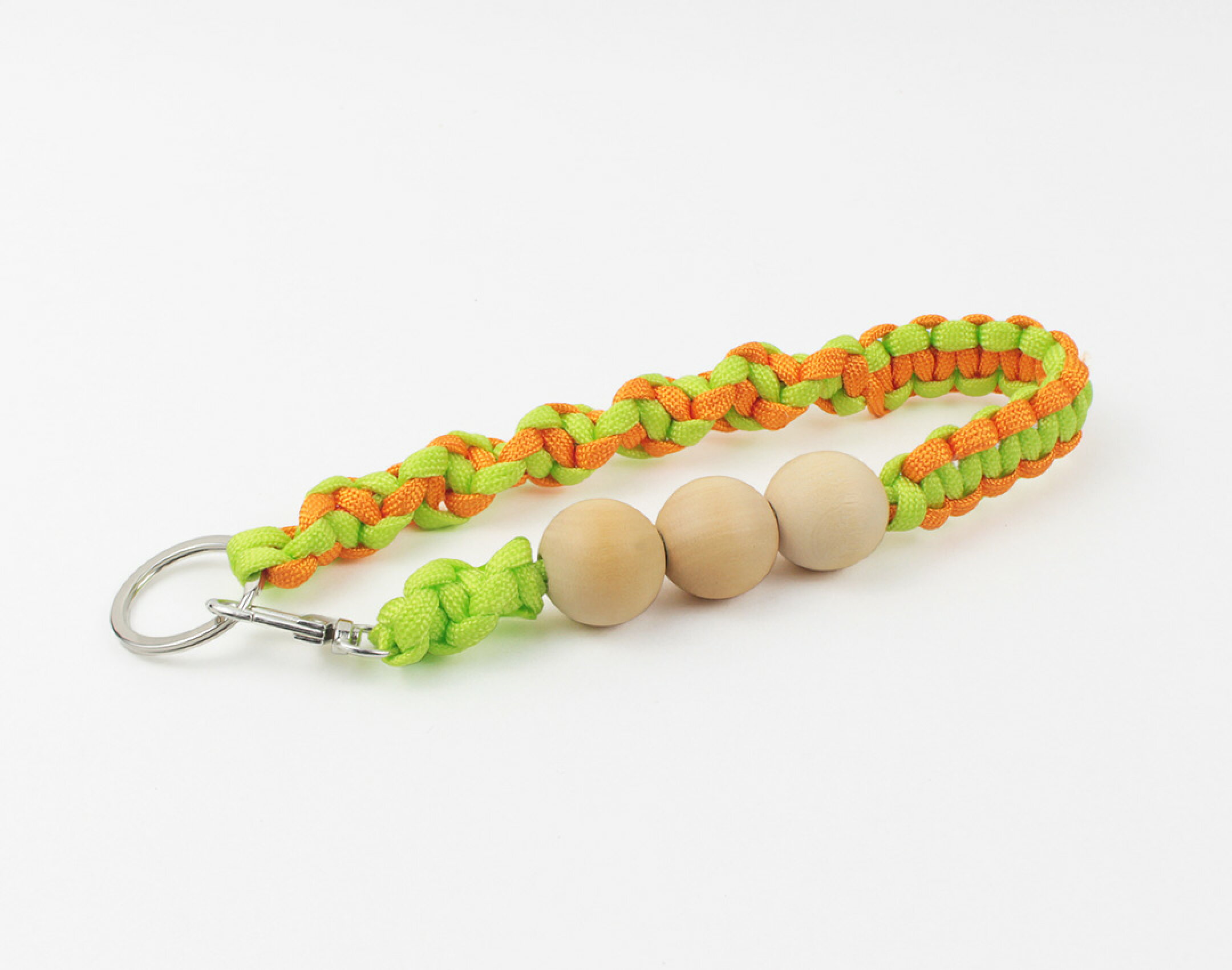 パラコードを使用したハンドメイドスマホストラップです。明るいカラーのパラコードにウッドビーズを組み合わせました。グリーンとオレンジが木目とマッチしてとても可愛いです。スマホの落下防止にも便利で実用的な作品です。
