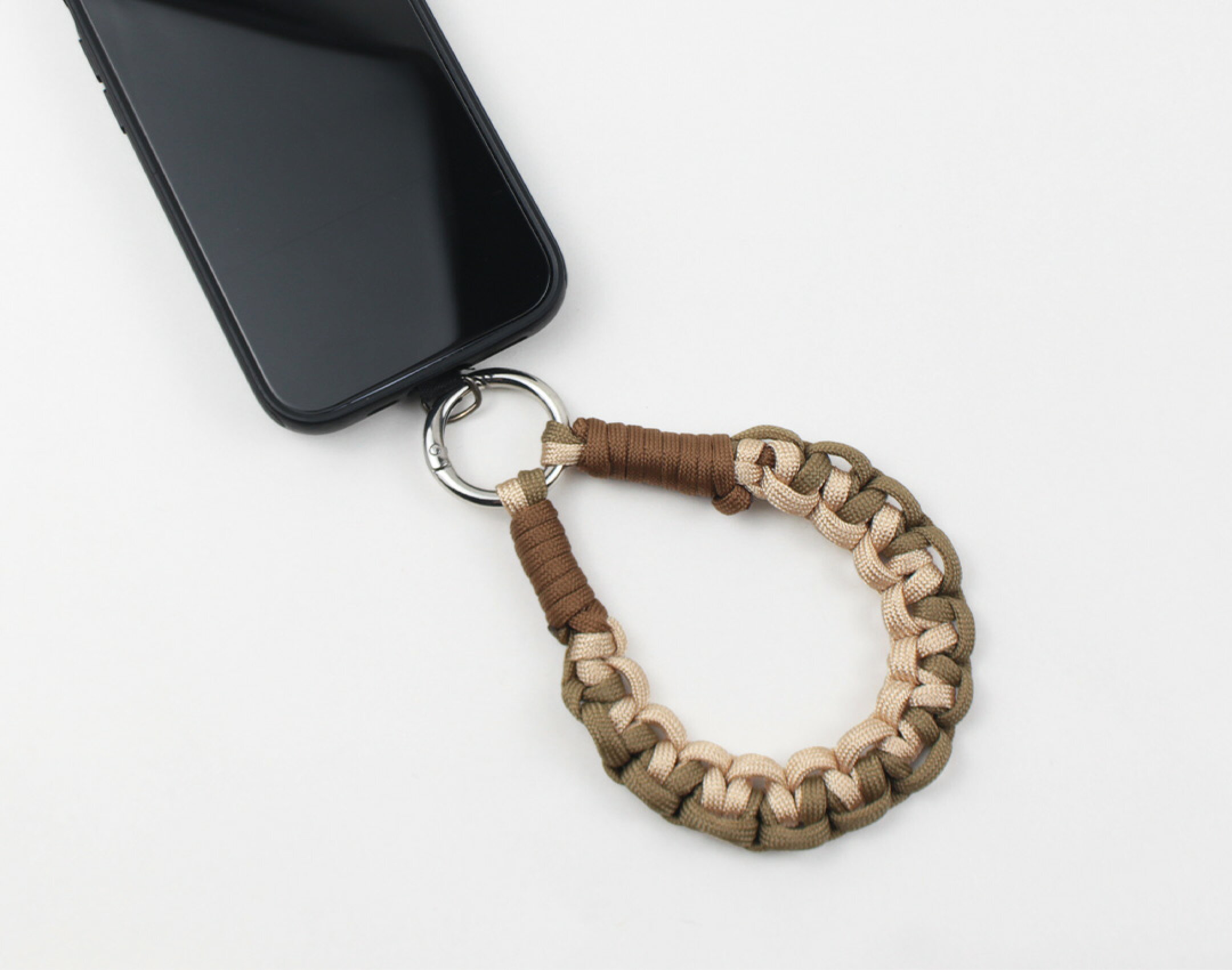 パラコードを使用したハンドメイドスマホストラップです。シンプルですが見え方のこだわった作品です。２種類の編み方で仕上げました。ゆるく編むことでぷっくり感が出てかわいらしく見えます。編み方に強弱を付けることで仕上がりにも差が出ます。