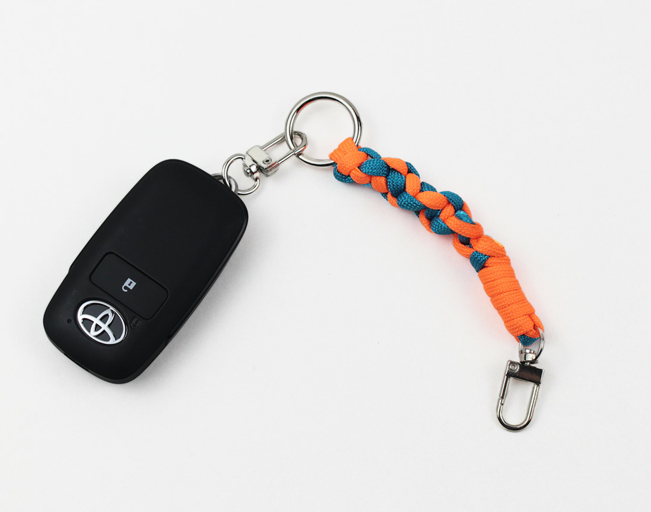 パラコードを使用したハンドメイドキーホルダーストラップです。２色使用したシンプルな作品。バッグの持ち手などに輪っかにして鍵などをぶら下げるのにちょうどいいサイズです。オレンジの発色にちらりとブルーが見えて可愛い作品です。