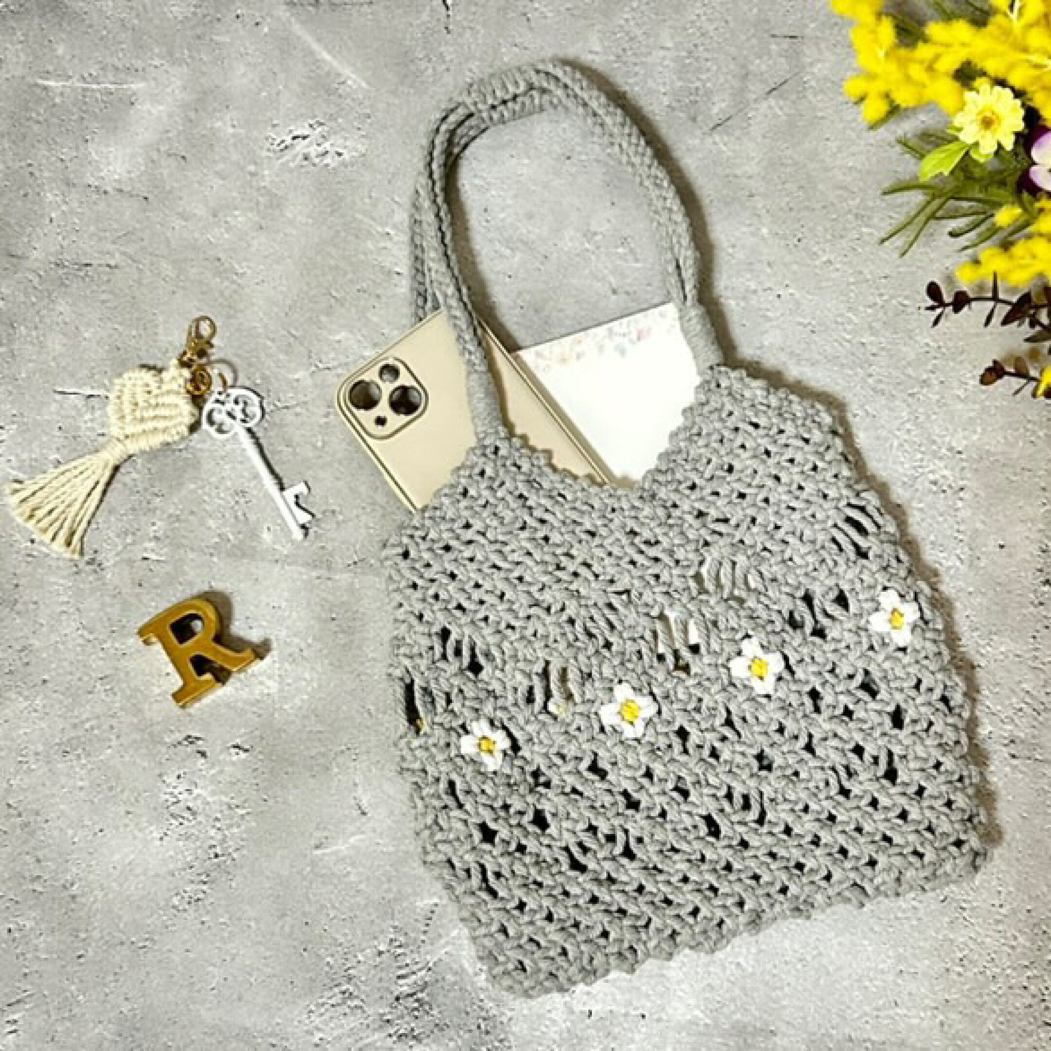 マクラメーロープを使用したトートバッグです。ホワイトのお花をポイントにしたかわいらしいデザインです。ちょっとしたお出かけにぴったりサイズです。柔らかくて編みやすいので大きな作品作りにも使いやすいマクラメ糸になります。