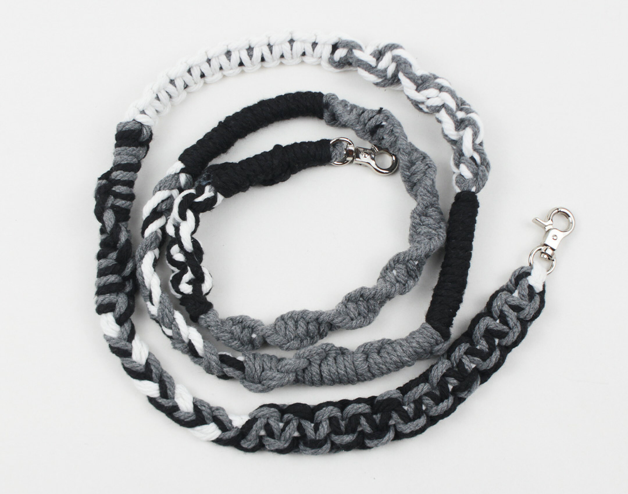 マクラメ糸を使用したスマホショルダーです。ブラック、ホワイト、グレーを使用したどなたでも使いやすいカラーになります。平編みなどの編み方をいくつも作ることで個性的なデザインになるように仕上げました。コットンならではの優しさを生かしています。