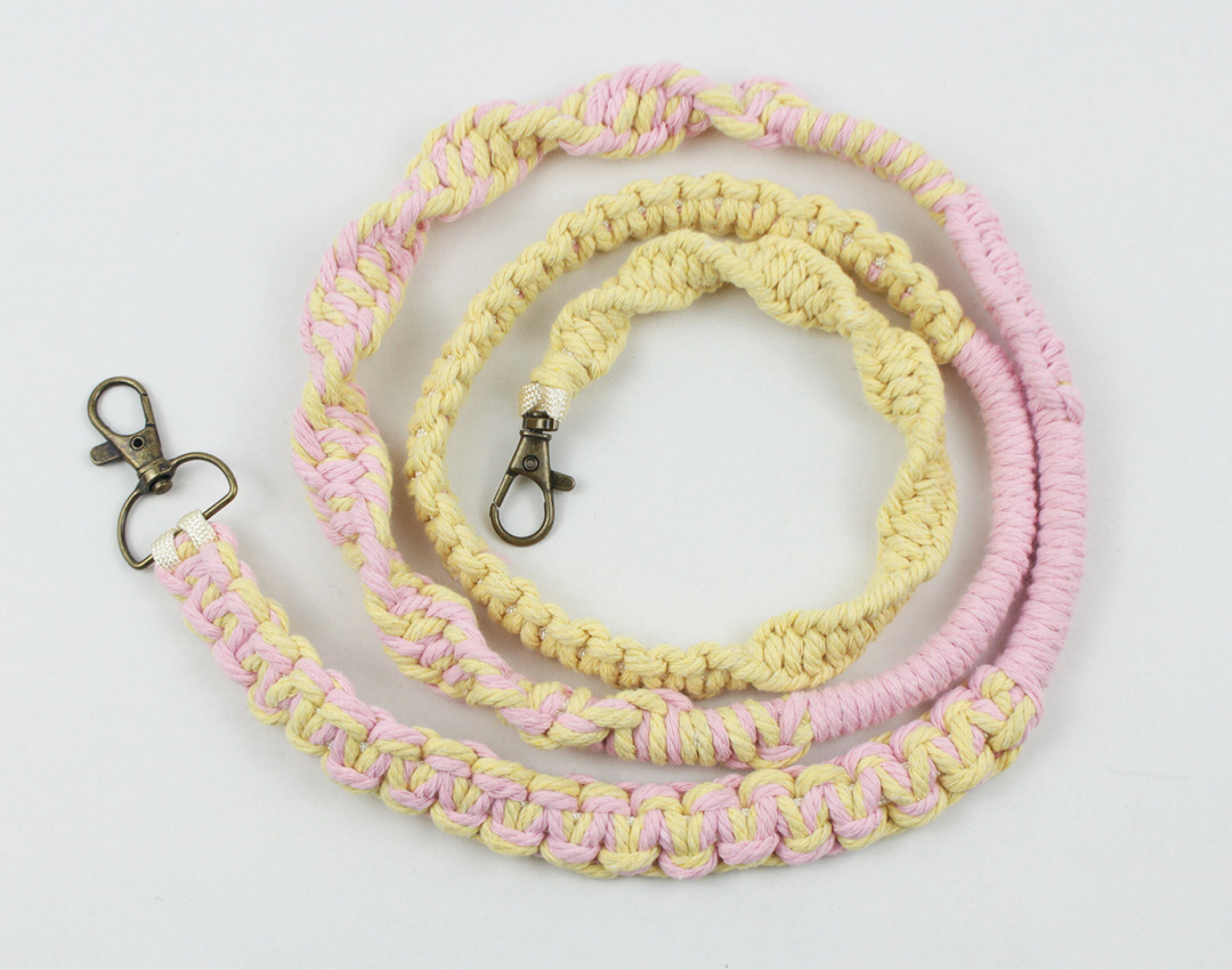 マクラメ糸を使用したスマホショルダーです。ピンクやイエロー系を使用して優しい感じに仕上げました。平編みなどの編み方をいくつも作ることで個性的なデザインになるように仕上げました。コットンならではの優しさを生かしています。