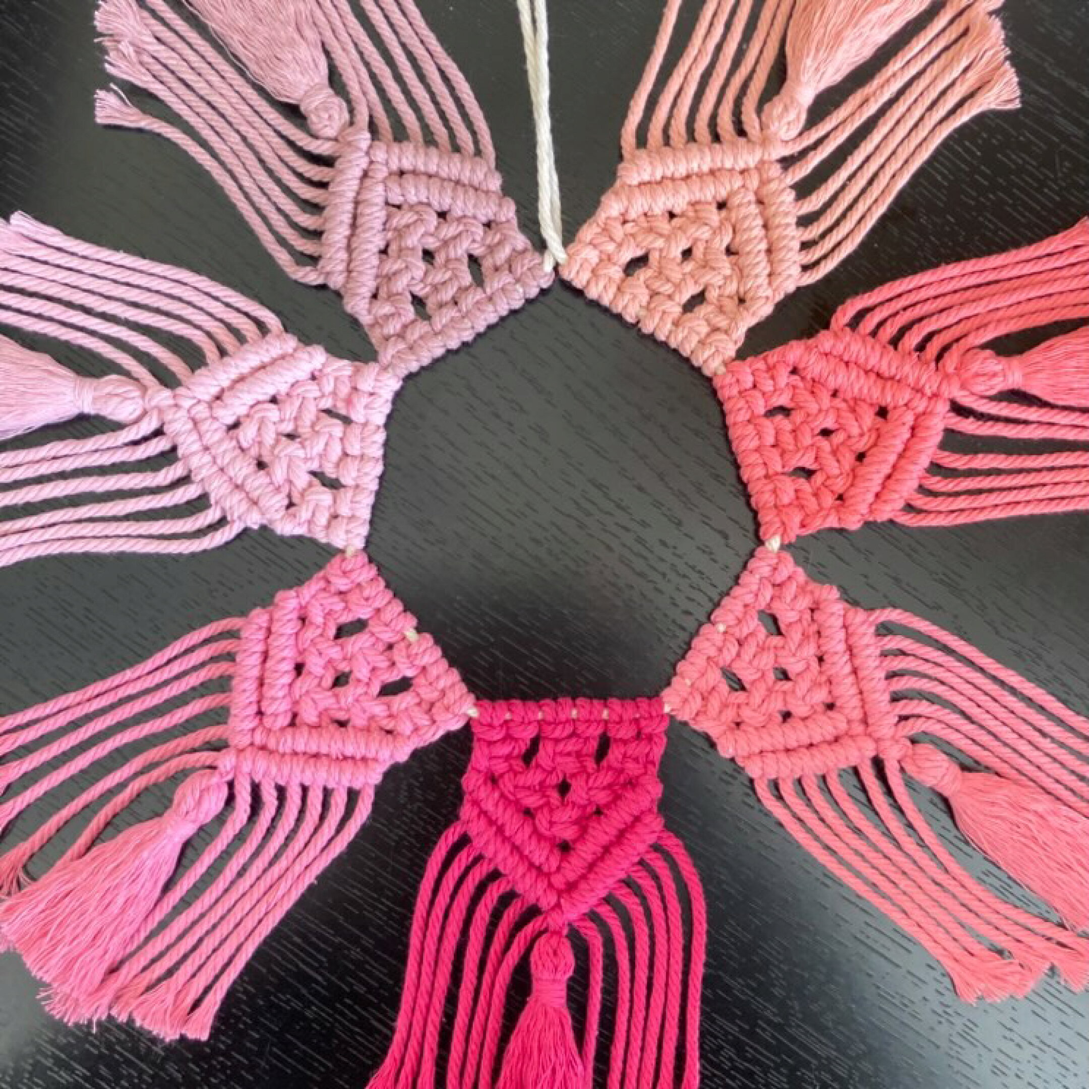 マクラメーロープを使用して作ったグラデーションタペストリーになります。ピンク系の色を並べた作品です。同色を並べることでグラデーションにしてもとても可愛いですね。４８色から選べるマクラメ糸なので他のカラーでも作ってみたくなります。