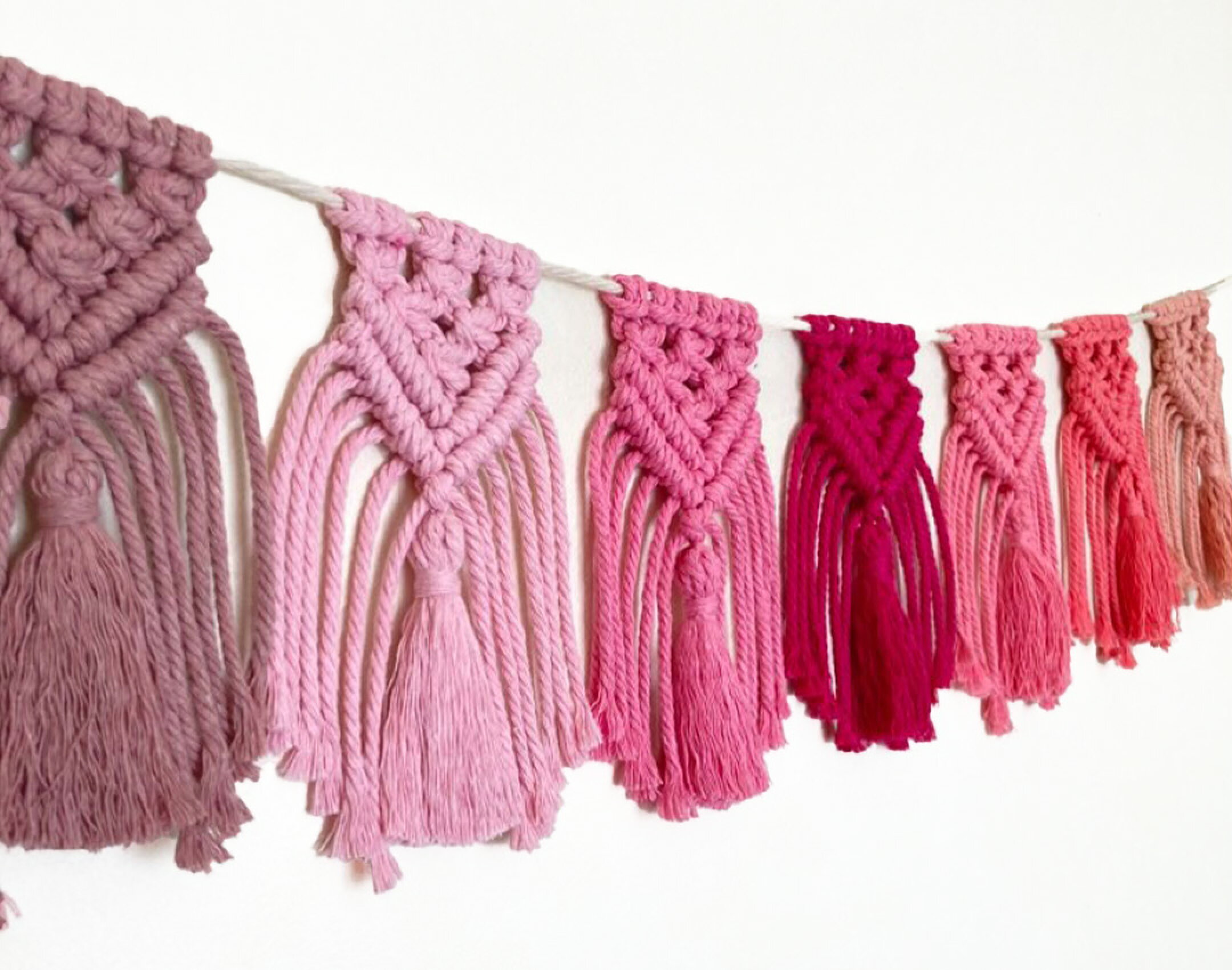 マクラメーロープを使用して作ったグラデーションタペストリーになります。ピンク系の色を並べた作品です。同色を並べることでグラデーションにしてもとても可愛いですね。４８色から選べるマクラメ糸なので他のカラーでも作ってみたくなります。