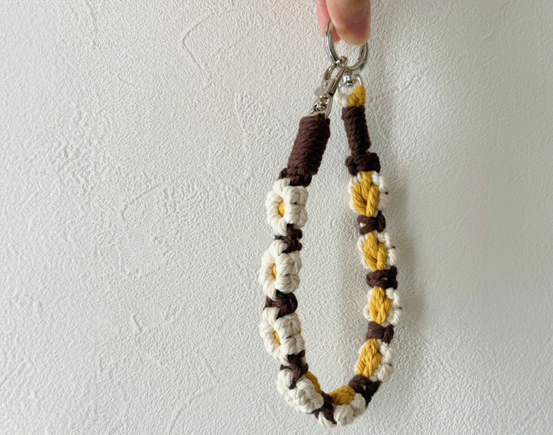 カラーにメリハリをつけたお花編みのハンドストラップです。系統の違うカラーでメリハリを付けています。作品のようなカラーでもまとまった仕上がりになるのもマクラメ糸の特徴で様々なカラーでも組み合わせやすいです。