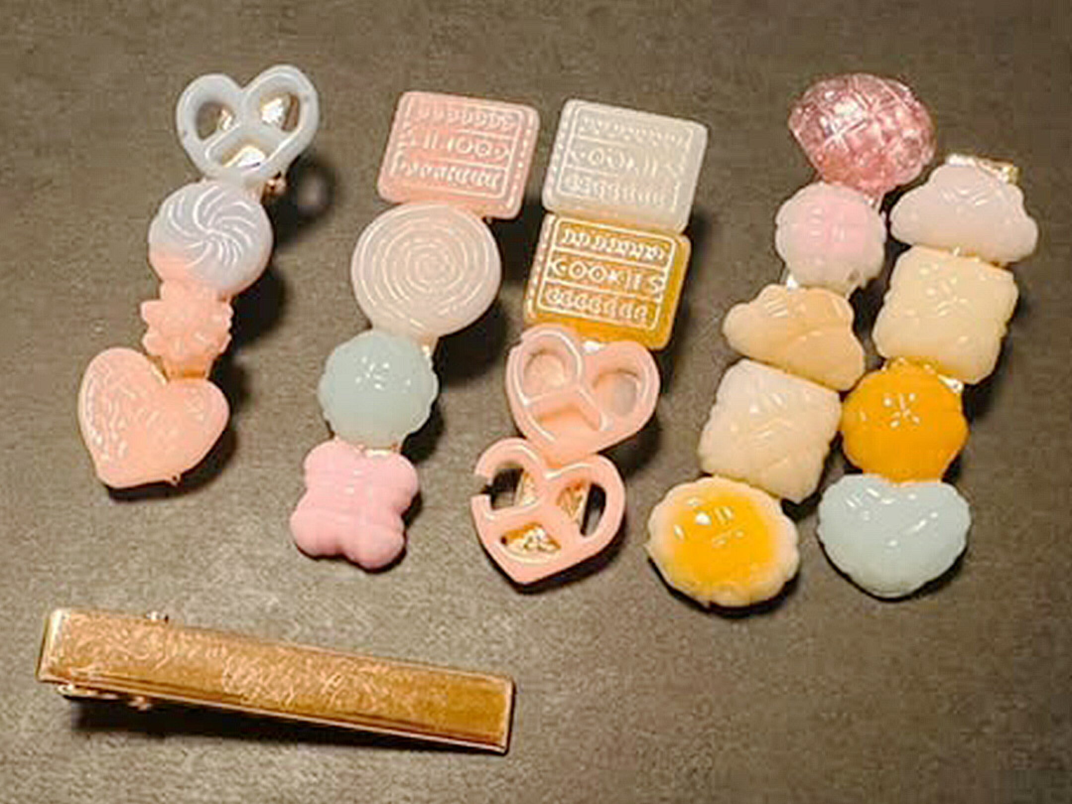 淡いピンクやイエロー、乳白色のパーツを組み合わせたハンドメイドアクセサリー作品。レジン素材のヘアアクセサリーやヘアピンが並び、やさしい色合いと可憐なデザインが春らしさを演出