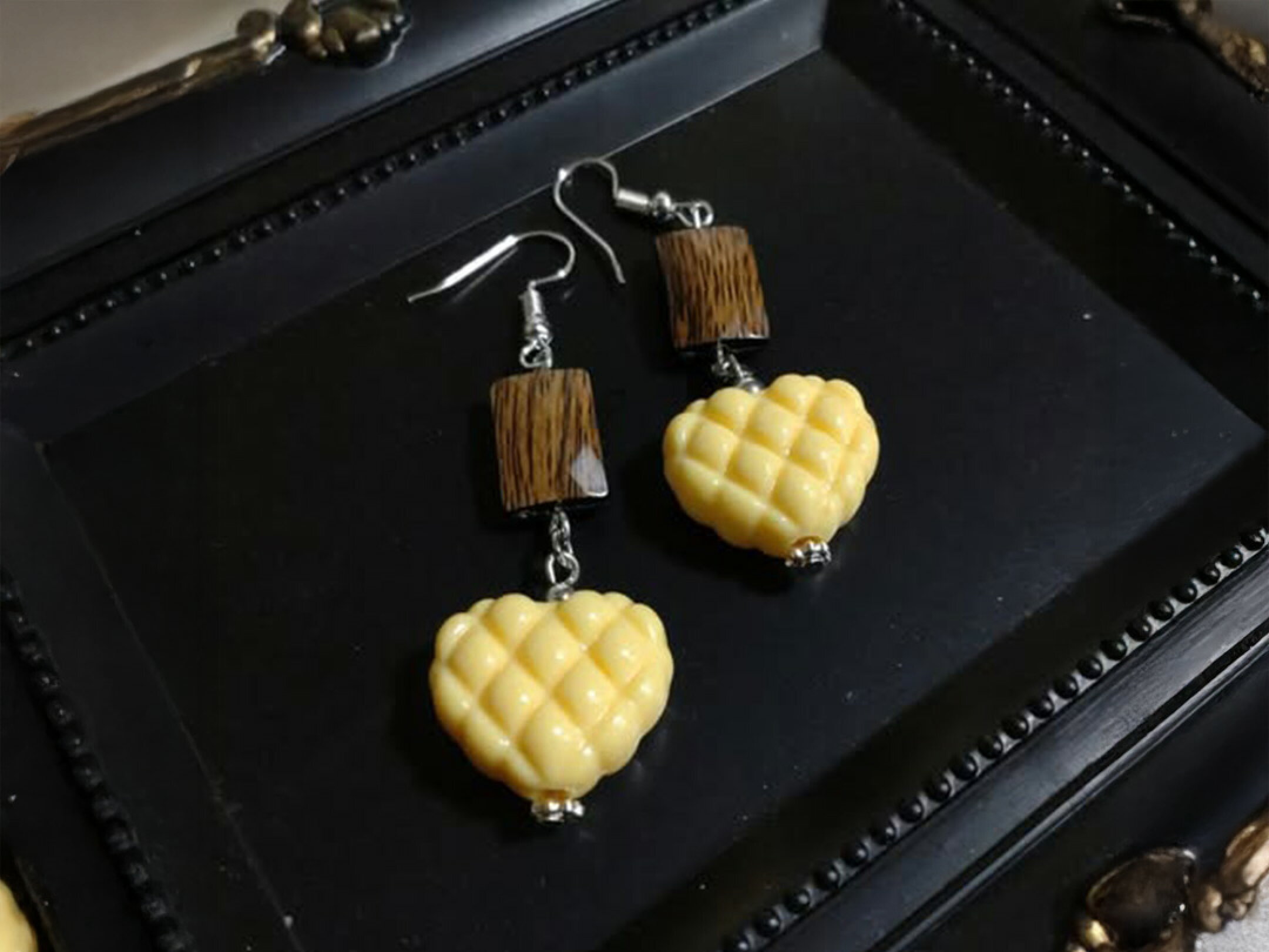 ウッドビーズとハート型ビーズを組み合わせたハンドメイドピアス作品。異素材ミックスのあたたかみあるデザインで、揺れるフォルムが耳元を優しく彩るナチュラルなアクセサリー