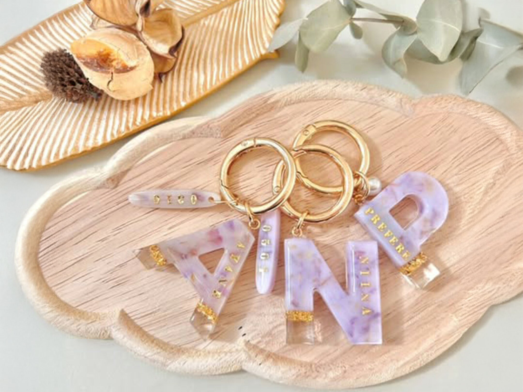 淡いラベンダー色のレジンにゴールドの文字をあしらった、イニシャルデザインのキーホルダー作品。透明感のあるマーブル模様と上品な金具の組み合わせが優しく洗練された印象を与える。バッグや鍵につけるだけで特別感が生まれ贈り物にもぴったりな大人可愛いアクセサリー