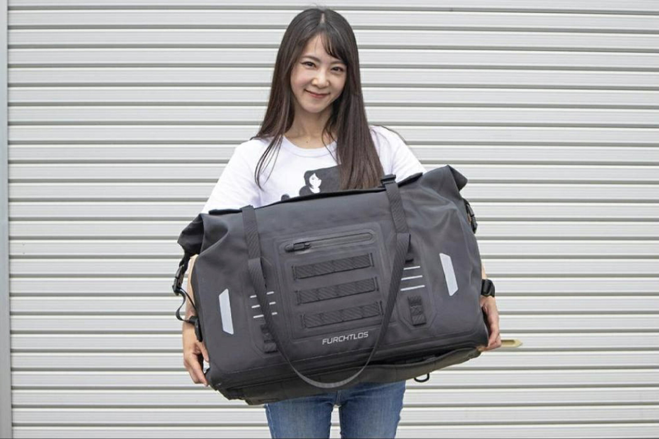身長163cmの女性がEVEREST Duffel Bag 50Lを両手で持った様子
