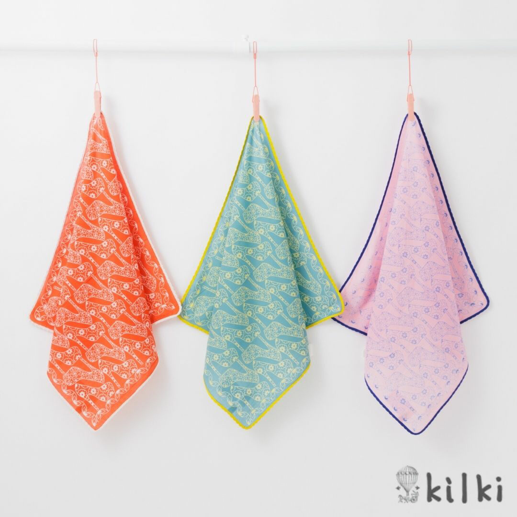 ブランドKILKI（キルキー）の大判コットンハンカチ特集。「シューズ」はハイヒールとお花の柄が詰まったおしゃれハンカチ。お洋服やファッション好きな女性へのプレゼントにおすすめです。フチにあしらわれた配色パイピングが映えるセンス抜群のアイテムです。